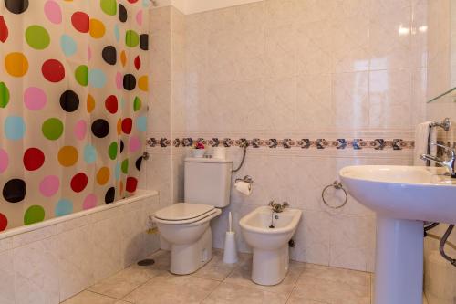 een badkamer met een toilet en een wastafel bij cantinho do mar in Albufeira