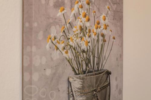 a vase with white and yellow flowers in it at Seenaah auf der Insel Lindau Nr 8 in Lindau