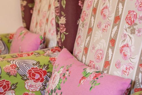 a row of pillows on a bed with floral wallpaper at Seenaah auf der Insel Lindau Nr 8 in Lindau