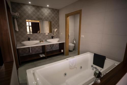 a bathroom with two sinks and a bath tub at Hotel Radika in Mavrovo