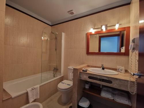 uma casa de banho com um lavatório, um WC e um chuveiro em Hotel A Bota no Portonovo