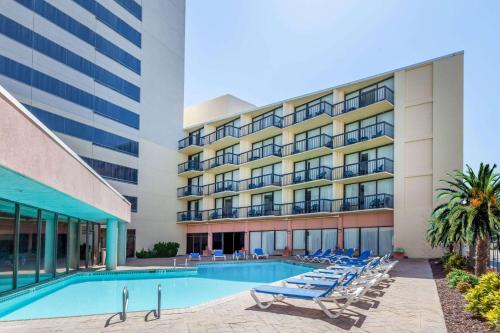 a swimming pool in front of a building at Wyndham Virginia Beach Oceanfront in Virginia Beach