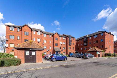 a parking lot with cars parked in front of brick buildings at Suites by Rehoboth - 23 Thames View - Upper - Woolwich in London