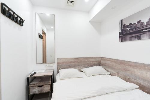 a white bedroom with a bed and a mirror at 7 days hotel in Almaty