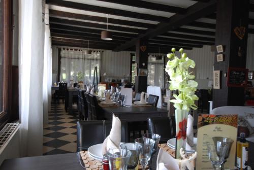 a dining room with tables and chairs in a restaurant at Hotel & Restaurant Le Chalvet in Embrun