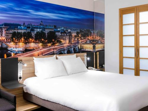 um quarto com uma cama branca e vista para a cidade em Novotel Paris 14 Porte d'Orléans em Paris