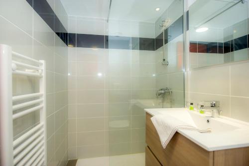 une salle de bain avec un lavabo et une douche dans l'établissement Village vacances de Marc, à Auzat
