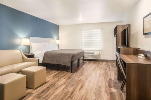 a hotel room with a bed and a couch at WoodSpring Suites Atlanta Newnan in Newnan