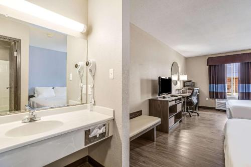 um quarto de hotel com um lavatório e um quarto em Quality Inn Calvert City - Paducah East em Calvert City