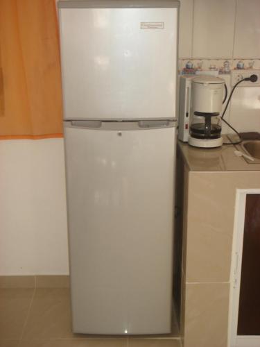 a white refrigerator in a kitchen next to a counter at Dre Broeders Apartments Juan Dolio in Juan Dolio