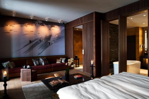 a bedroom with a large painting on the wall at The Chedi Andermatt in Andermatt