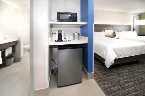 Tempat tidur dalam kamar di Holiday Inn Express & Suites - Fort Myers Airport, an IHG Hotel