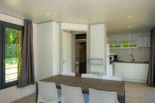 une cuisine et une salle à manger avec une table et des chaises dans l'établissement Village de vacances Les Lambrilles, à La Bastide-de-Sérou