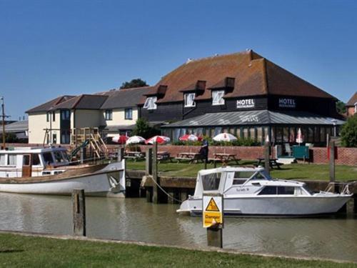 two boats docked in the water in front of a building at The River Haven Hotel in Rye