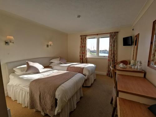 a hotel room with two beds and a window at The River Haven Hotel in Rye