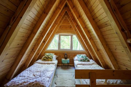 2 camas en el ático de una cabaña de madera en Duża Woda, en Dąbrówno