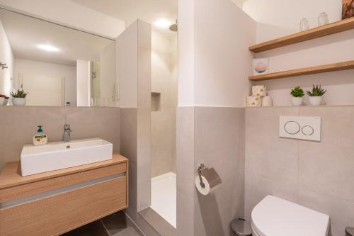 ein Badezimmer mit einem Waschbecken, einem WC und einem Spiegel in der Unterkunft Alpseeglück in Immenstadt im Allgäu
