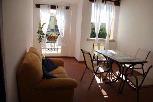 a living room with a couch and a table and chairs at Appartamento Le Vele in Porto San Paolo