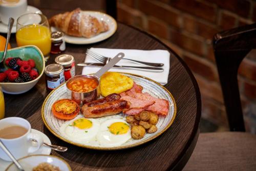 a table with a plate of breakfast food on it at Crowne Plaza Nottingham by IHG in Nottingham