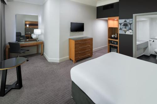 a hotel room with a bed and a desk and a television at Crowne Plaza Nottingham by IHG in Nottingham