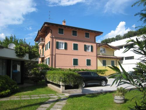 uma casa com um carro estacionado em frente em Bella Villa Apartments em Riva del Garda