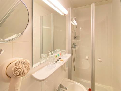 a bathroom with a shower and a sink and a toilet at Hotel Rathausglöckel in Baden-Baden