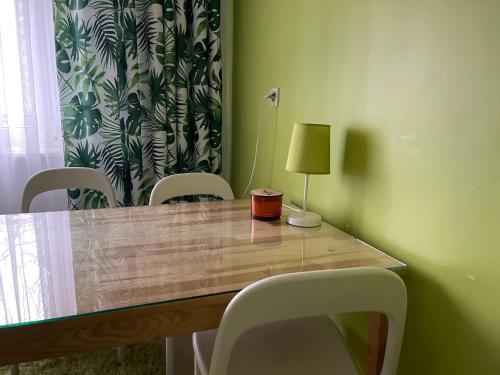 einen Tisch mit Stühlen und eine Lampe darüber in der Unterkunft Apartament PolnaHouse in Sieradz
