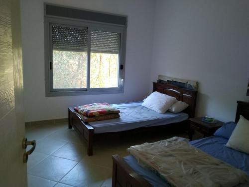 Habitación con 2 camas y ventana en einbay 3 bedrooms garden + pool view, en Ain Sokhna