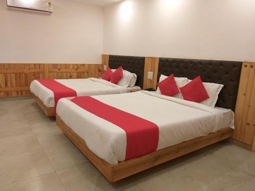 格德拉Hotel Bali Resort extension的房间里有两张床，床单是红色和白色的