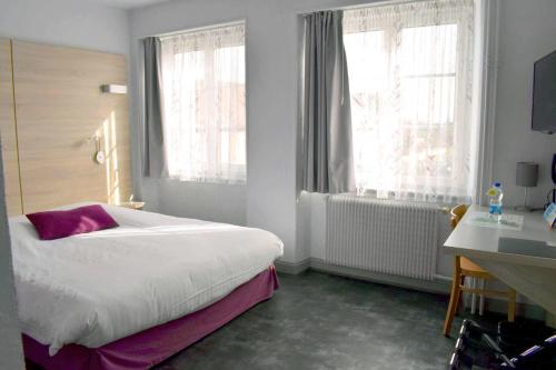 ein Schlafzimmer mit einem großen Bett und zwei Fenstern in der Unterkunft Le rendez-vous des Copains in Logelheim