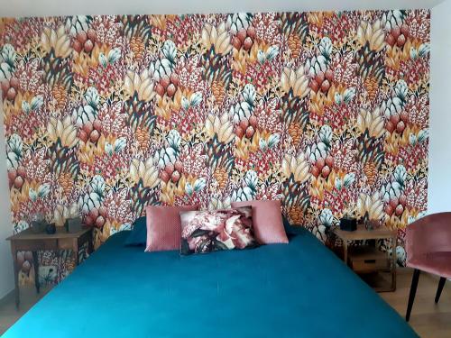 a bedroom with a blue bed with a floral wallpaper at B&B Caprice d'Epices in Francorchamps