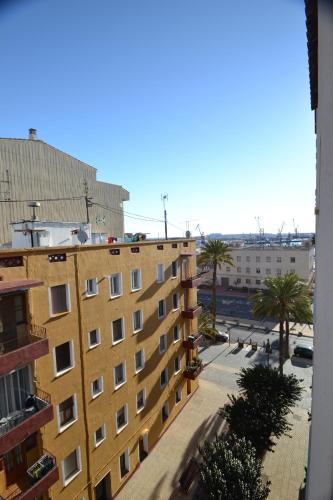 a view of a building and a street with palm trees at Apartamentos Marina Suites in Grao de Castellón