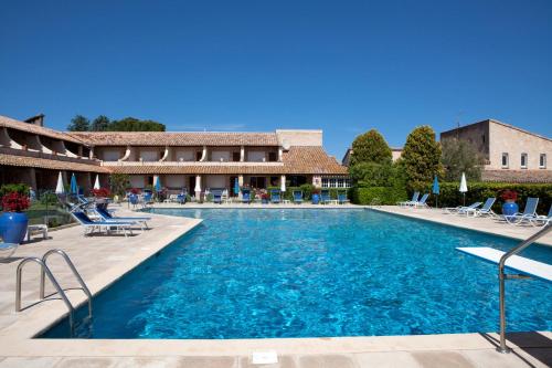 une piscine avec des chaises et un bâtiment dans l'établissement La Côte Bleue, à Bouzigues