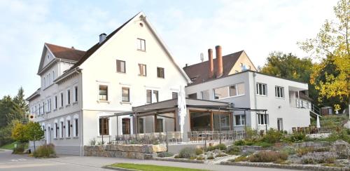 ein großes weißes Haus mit einer Veranda in der Unterkunft Land-gut-Hotel Landgasthof zur Rose in Ehingen