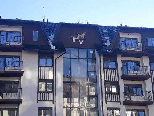 a building with a tvl sign on the front of it at Apartman Spas Titova Vila Zlatibor in Palisad