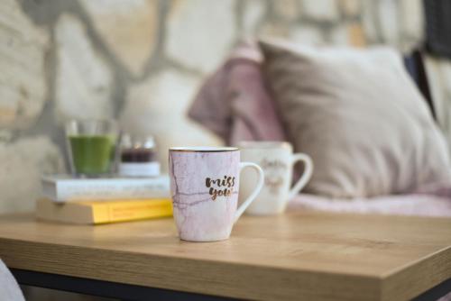 two coffee cups sitting on a wooden table at Apartman Spas Titova Vila Zlatibor in Palisad