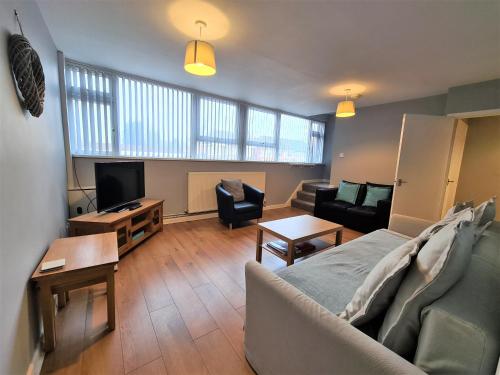 a living room with a couch and a tv at 3 Bedroom Apartment Coventry - Hosted by Coventry Accommodation in Coventry