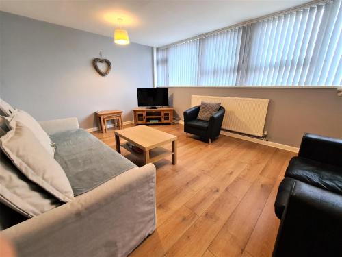 ein Wohnzimmer mit einem Sofa und einem Tisch in der Unterkunft 3 Bedroom Apartment Coventry - Hosted by Coventry Accommodation in Coventry