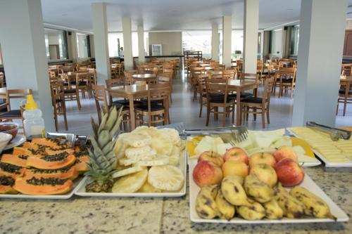 two trays of food on a table in a restaurant at Porto Mar Hotel in Porto Seguro