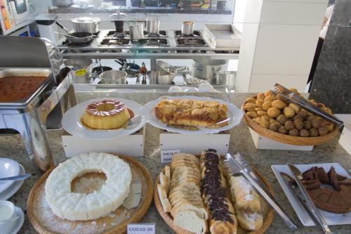 a bunch of different types of pastries on a counter at Porto Mar Hotel in Porto Seguro