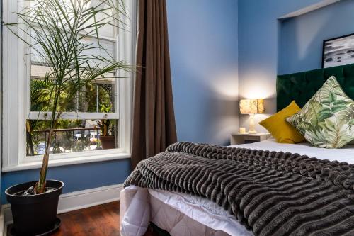 sypialnia z dużym łóżkiem i oknem w obiekcie Obz Hotel w Kapsztadzie