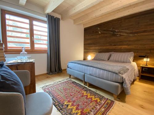 1 dormitorio con 1 cama y pared de madera en B & B Chalet Plan, en Strembo