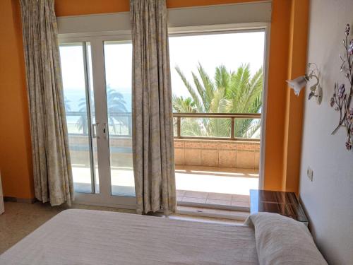 1 dormitorio con cama y ventana grande en Estepona primera línea de playa, apartamento 2-4 personas, en Estepona