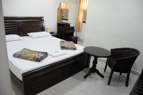 a bedroom with a bed with a desk and a chair at Lloyds Serviced Apartments, Near Music Academy in Chennai