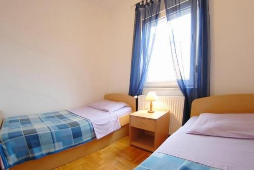 mała sypialnia z dwoma łóżkami i oknem w obiekcie Apartment in Medulin with Terrace, Air conditioning, Wi-Fi, Washing machine (3479-1) w Medulinie