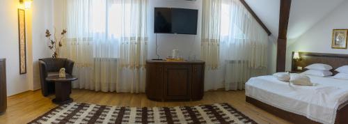 a bedroom with a bed and a flat screen tv at Boutique Hotel L do Rado in Sofia