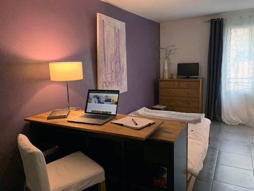 een kamer met een bureau en een laptop. bij Zentral Studio in Gif-sur-Yvette