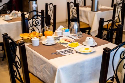 a table with breakfast food on a white table cloth at Hotel Machupicchu Inn in Machu Picchu