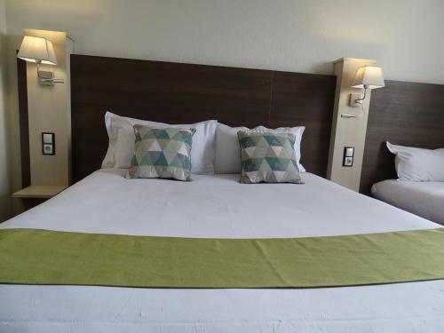 a bedroom with a large bed with two pillows at Euro Hôtel Airport Orly Rungis in Fresnes