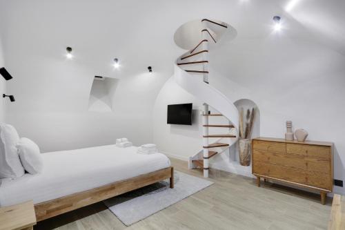 una camera bianca con un letto e una scala di Pick A Flat's Apartment in Neuilly sur Seine - Avenue Charles de Gaulle a Neuilly-sur-Seine